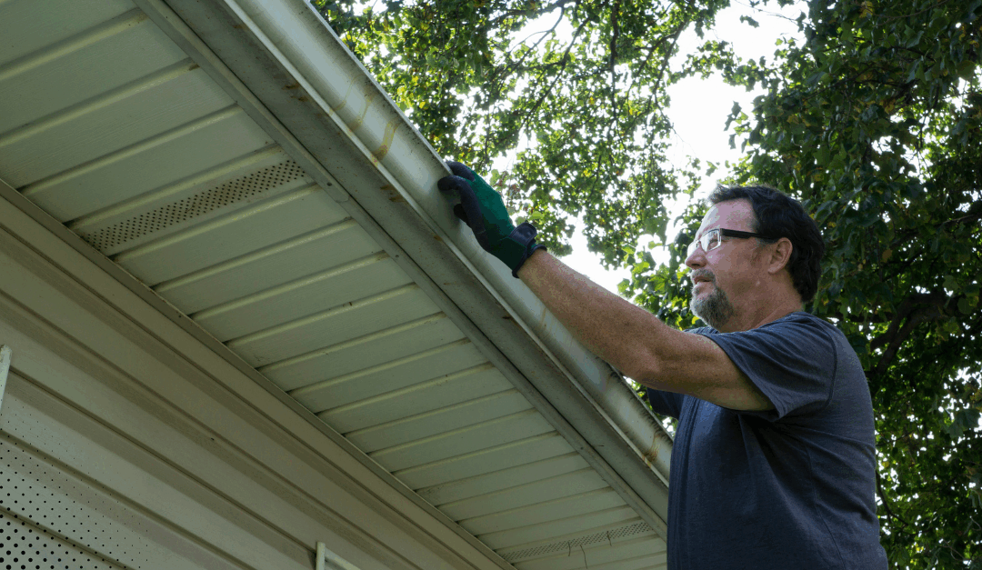 Inspector checking soffit and fascia along the roofline.